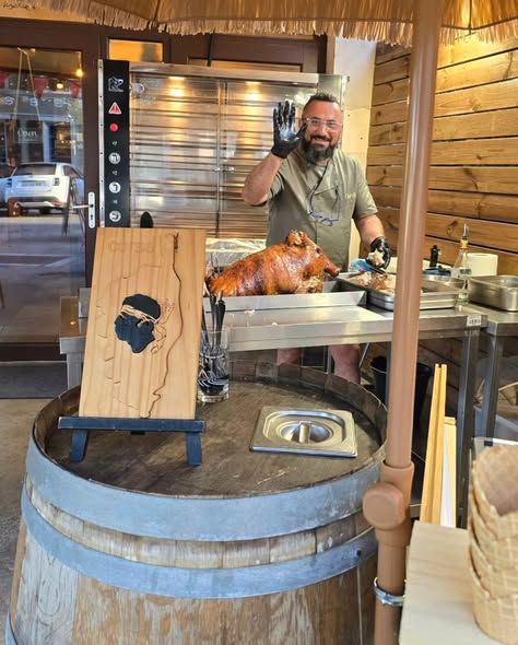 Cochon rôti à la broche à côté d'une planche en bois découpée en forme de Corse