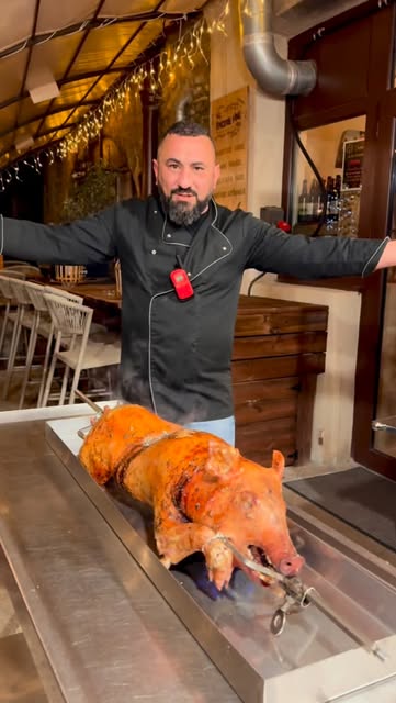 Le chef devant un cochon de lait rôti à la broche
