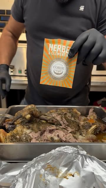 Sachet d'herbes et clémentine de Corse au-dessus d'un plat d'agneau effiloché