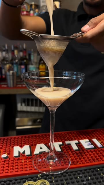 Cocktail crémeux filtré dans une coupe au comptoir