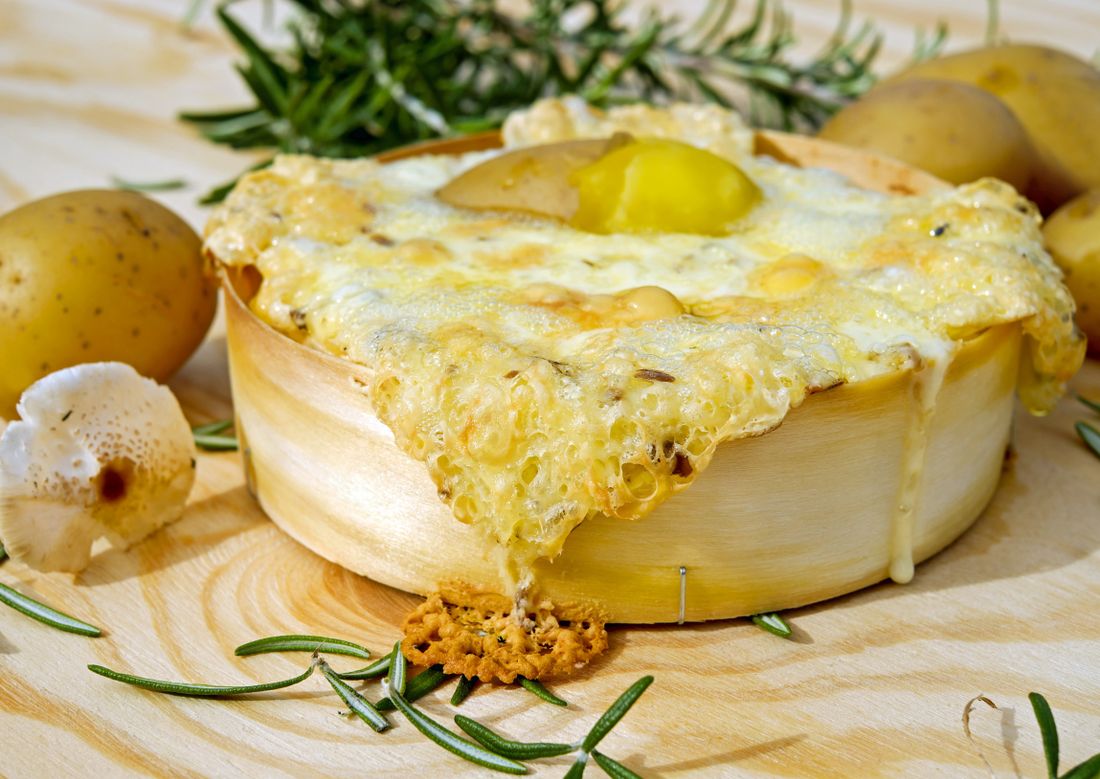 Fromage gratiné sur pommes de terre et champignons, brins de romarin (photo d'illustration)